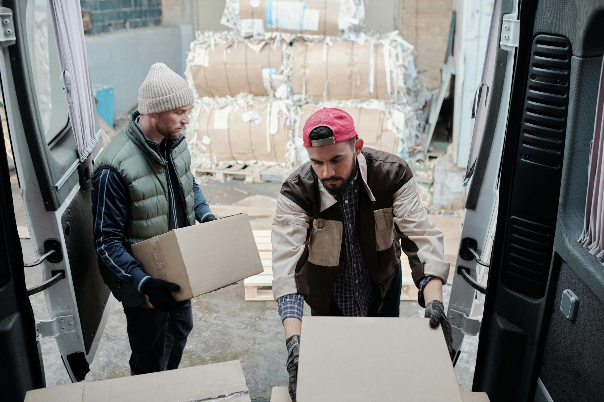 Due lavoratori che caricano e scaricano scatoloni